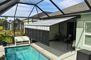 grey and white striped retractable awning with drop down shade screen
