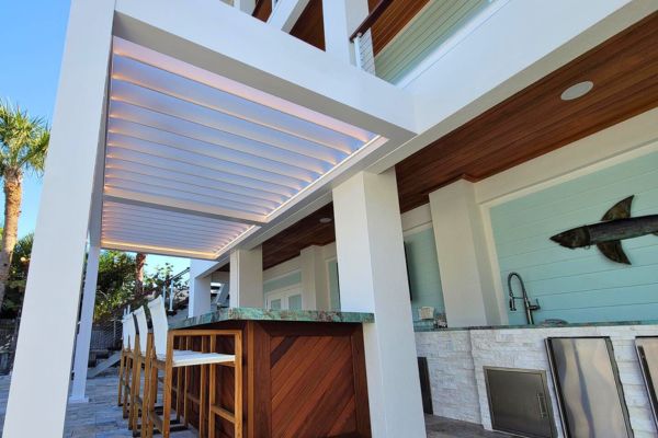 White Louvered Pergola White louvered pergola over bar countertop and bar stools