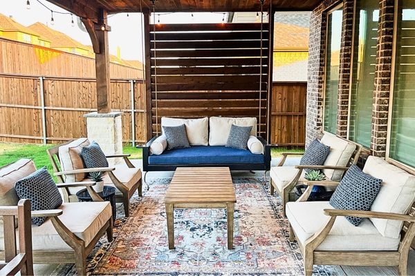 Backyard Retreat Backyard with beige patio chairs and sofas decorated with blue pillows