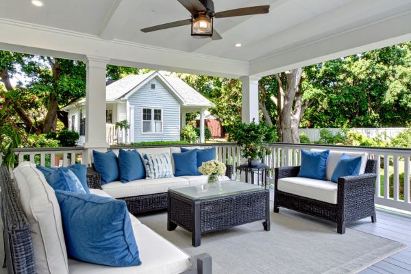 Small Town Porch Porch with black wicker furniture with white cushions and blue pillows