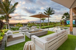 backyard with view of the ocean with white outdoor patio furniture and a patio umbrella