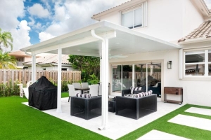 white pergola with black and white outdoor furniture underneath