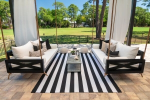 Double black swing beds facing each other with black and white rug in the middle