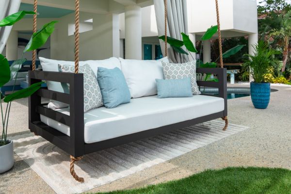 Shirley Swing Bed Black swing bed near pool with light blue pillows